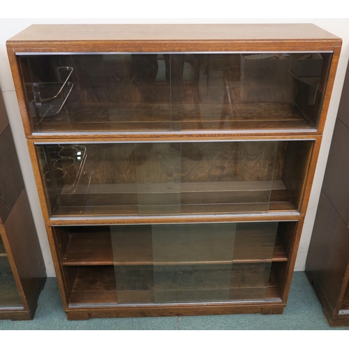 99 - A 20th century oak three tier stacking bookcase with glass sliding doors, 107cm high x 89cm wide x 2... 