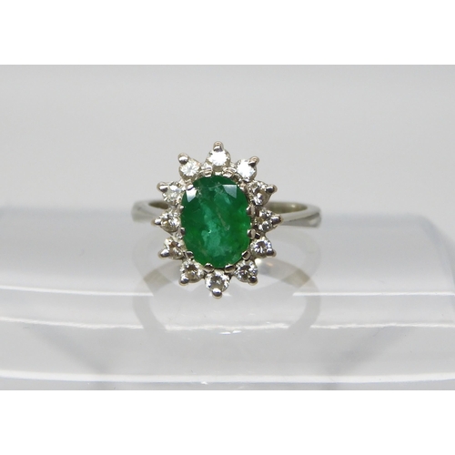 551 - A white metal emerald and diamond cluster ring, size F, set with estimated approx 0.20cts, together ... 