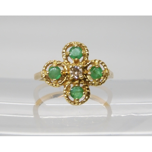 552 - An 18ct gold diamond and emerald flower ring, set with an estimated approx 0.08ct brilliant cut, fin... 