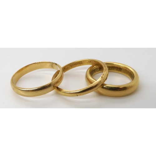 570 - A heavy weight ladies 18ct wedding ring, size J1/2, a gents 18ct wedding ring size R1/2, and a yello... 