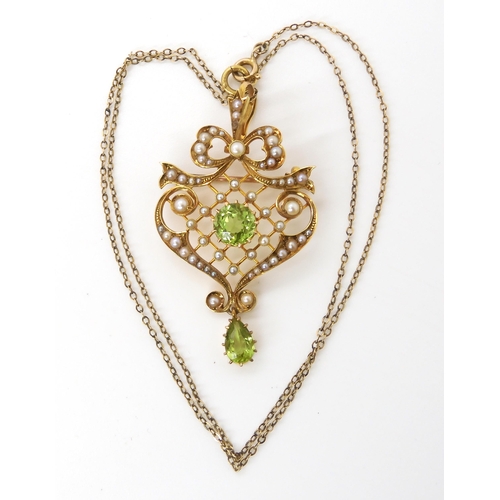 611 - A 15ct  gold peridot and pearl Edwardian pendant brooch, with a 9ct chain, weight combined 7.7g... 