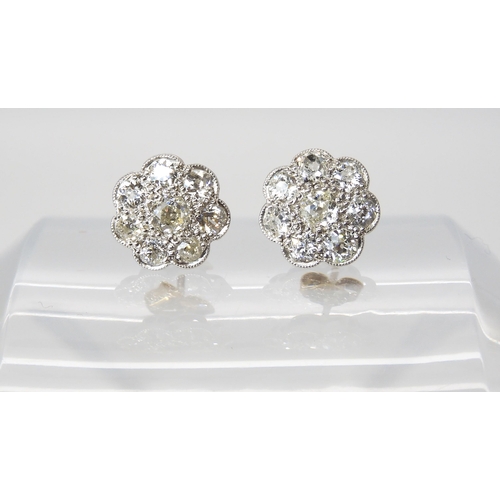 627 - A pair of white metal diamond flower earrings, set with estimated approx 1.60cts of old cut diamonds... 