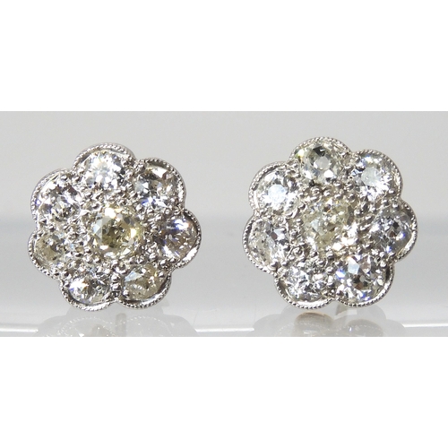 627 - A pair of white metal diamond flower earrings, set with estimated approx 1.60cts of old cut diamonds... 