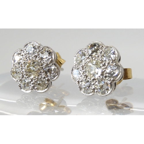 627 - A pair of white metal diamond flower earrings, set with estimated approx 1.60cts of old cut diamonds... 