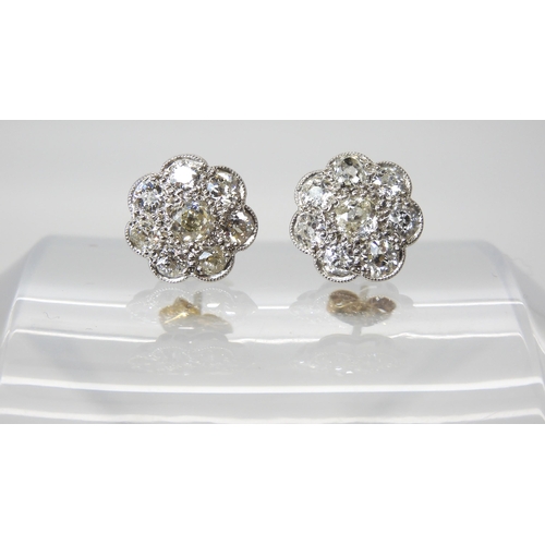 627 - A pair of white metal diamond flower earrings, set with estimated approx 1.60cts of old cut diamonds... 