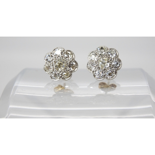 627 - A pair of white metal diamond flower earrings, set with estimated approx 1.60cts of old cut diamonds... 