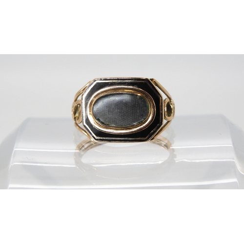 628 - A yellow metal and enamel mourning ring with glazed panel, finger size O1/2, weight 3.2gms