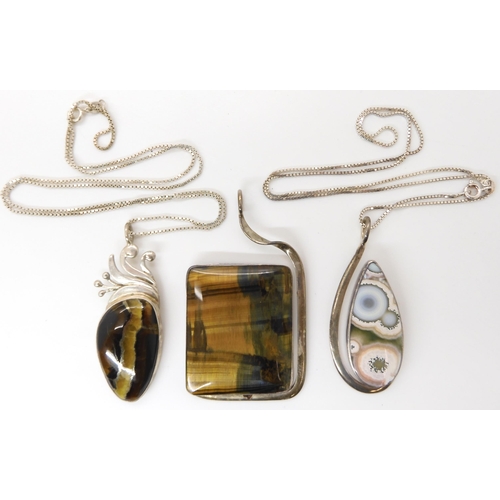 640 - Three American designer pendants made by Tom Burns, all three signed to include tiger's eye, marine ... 