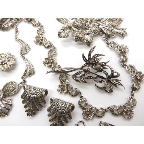 653 - A German silver marcasite flower brooch, together with a collection of further marcazite brooches in... 