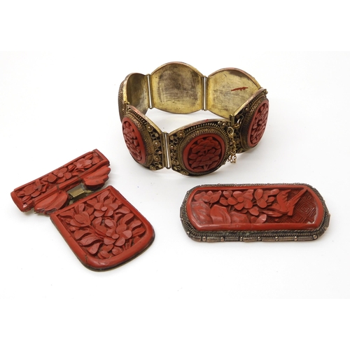 668 - A collection of Cinnabar items to include a bracelet, and two brooches