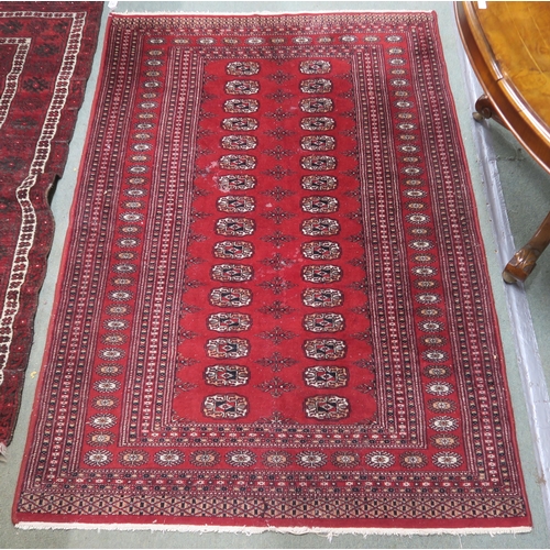 27 - A red ground Bokhara style rug with all over lozenge design, 188cm long x 127cm wide