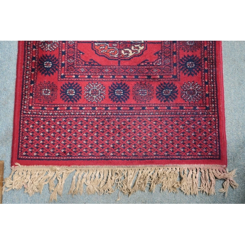 4 - A red ground Bokhara style runner, 273cm long x 69cm wide