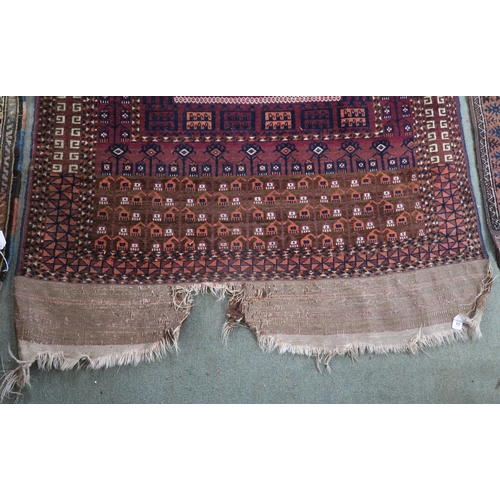 60 - A red ground Turkoman rug with multicoloured borders, 185cm long x 116cm wide