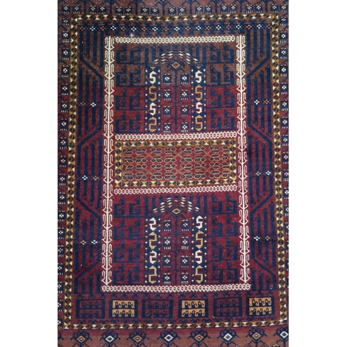 60 - A red ground Turkoman rug with multicoloured borders, 185cm long x 116cm wide