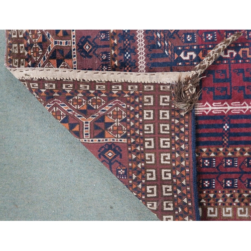 60 - A red ground Turkoman rug with multicoloured borders, 185cm long x 116cm wide