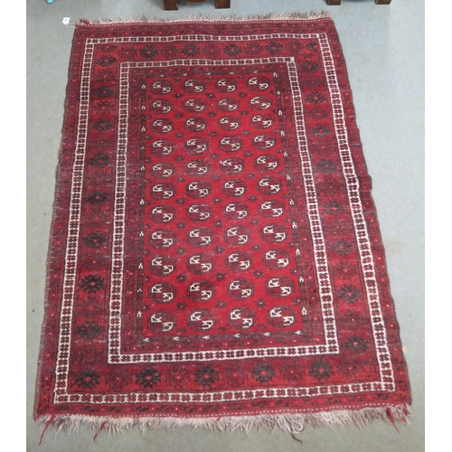 63 - A red ground Bokhara rug with all over lozenge design, 179cm long x 133cm wide...