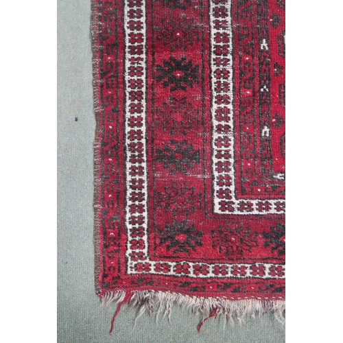 63 - A red ground Bokhara rug with all over lozenge design, 179cm long x 133cm wide