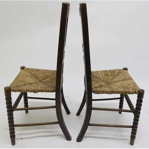 72 - A pair of early 20th century oak arts & crafts chairs with rush seats on turned bobbin supports,... 