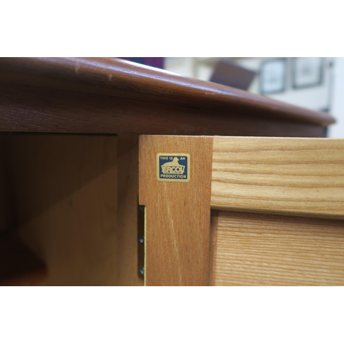 73 - A mid 20th century elm and beech Ercol sideboard with two central cabinet doors flanked by two drawe... 