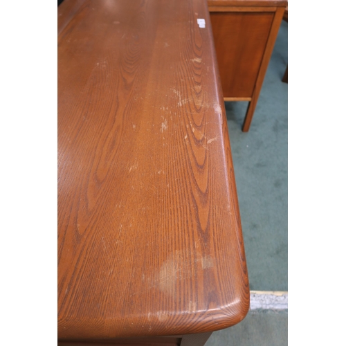 73 - A mid 20th century elm and beech Ercol sideboard with two central cabinet doors flanked by two drawe... 