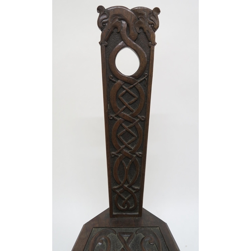 9 - A 20th century oak spinning chair with extensive Celtic carvings