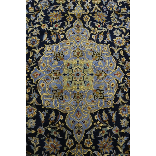 123 - A DARK BLUE GROUND KASHAN RUG with light blue central medallion ,matching spandrels and dark blue bo... 