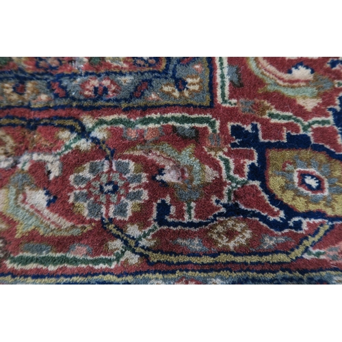 124 - A CREAM GROUND TABRIZ RUG with a light terracotta medallion, matching borders and dark blue spandrel... 