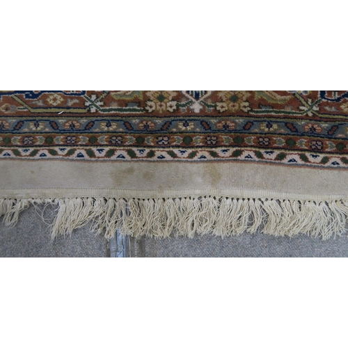 124 - A CREAM GROUND TABRIZ RUG with a light terracotta medallion, matching borders and dark blue spandrel... 