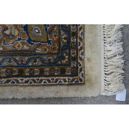 124 - A CREAM GROUND TABRIZ RUG with a light terracotta medallion, matching borders and dark blue spandrel... 