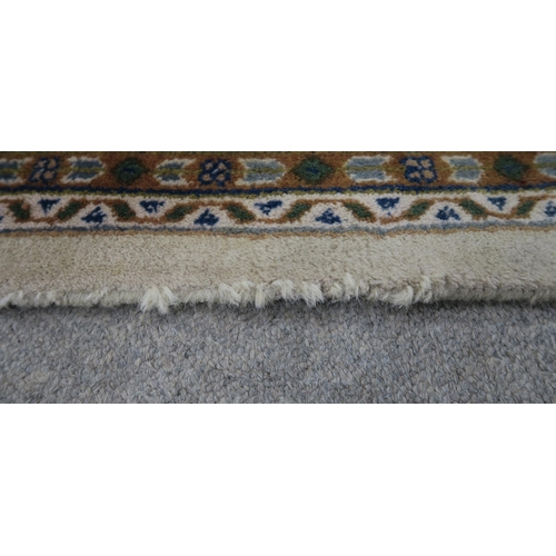 124 - A CREAM GROUND TABRIZ RUG with a light terracotta medallion, matching borders and dark blue spandrel... 