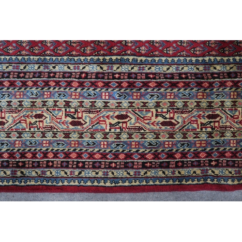 125 - A RED GROUND ARAAK RUG with multicoloured geometric borders 370cm long x 283cm wide... 