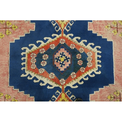 127 - A PINK & BLUE GROUND TURKISH KAYAM RUG with floral geometric central medallion and multicoloured... 