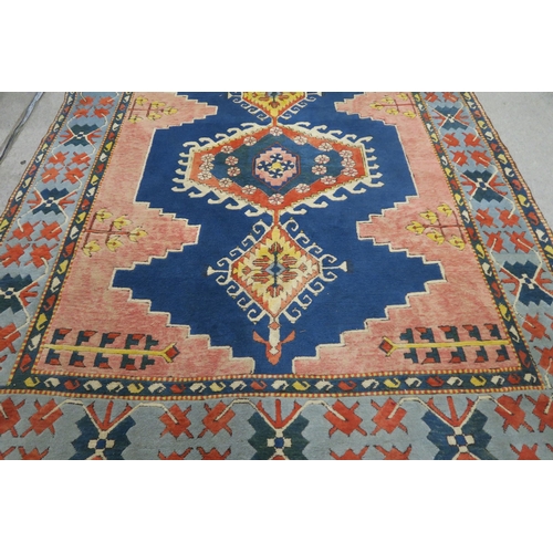 127 - A PINK & BLUE GROUND TURKISH KAYAM RUG with floral geometric central medallion and multicoloured... 