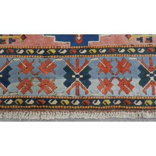 127 - A PINK & BLUE GROUND TURKISH KAYAM RUG with floral geometric central medallion and multicoloured... 