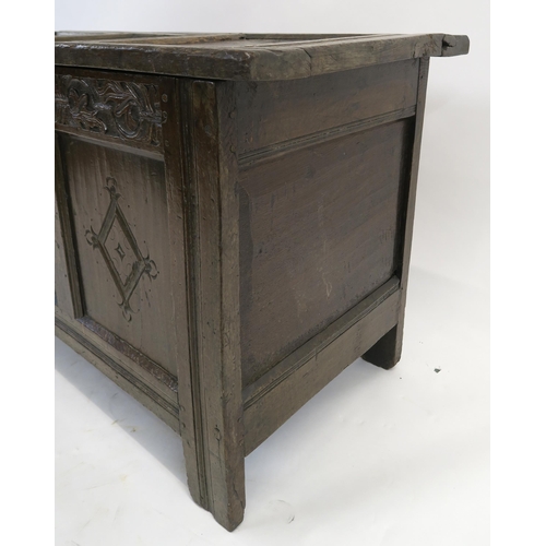 15 - AN 18TH CENTURY OAK COFFER the hinged lid set with three panels above a carved foliate frieze and th... 