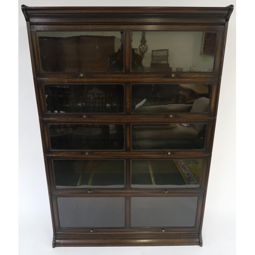 26 - AN EDWARDIAN STAINED OAK FIVE TIER SECTIONAL BOOKCASE with glazed in-swing doors 185cm high x 128cm ... 