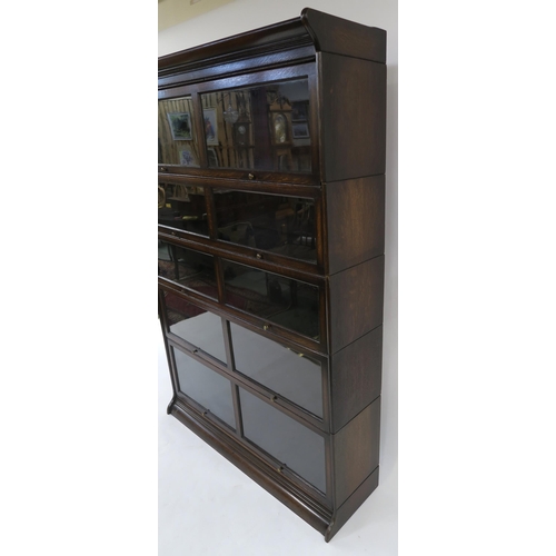 26 - AN EDWARDIAN STAINED OAK FIVE TIER SECTIONAL BOOKCASE with glazed in-swing doors 185cm high x 128cm ... 
