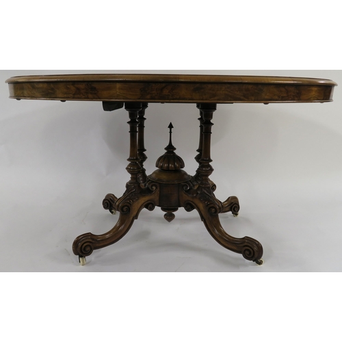 32 - A VICTORIAN WALNUT OVAL TILT TOP BREAKFAST TABLE on turned columns above carved quadripartite base 7... 
