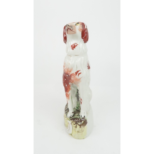 358 - A 19TH CENTURY STAFFORDSHIRE POTTERY DOG possibly an Irish Setter, modelled seated with red decorati... 