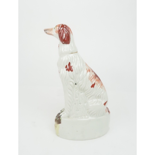 358 - A 19TH CENTURY STAFFORDSHIRE POTTERY DOG possibly an Irish Setter, modelled seated with red decorati... 