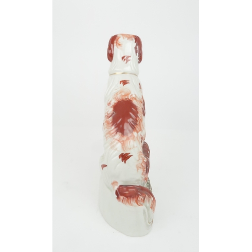 358 - A 19TH CENTURY STAFFORDSHIRE POTTERY DOG possibly an Irish Setter, modelled seated with red decorati... 