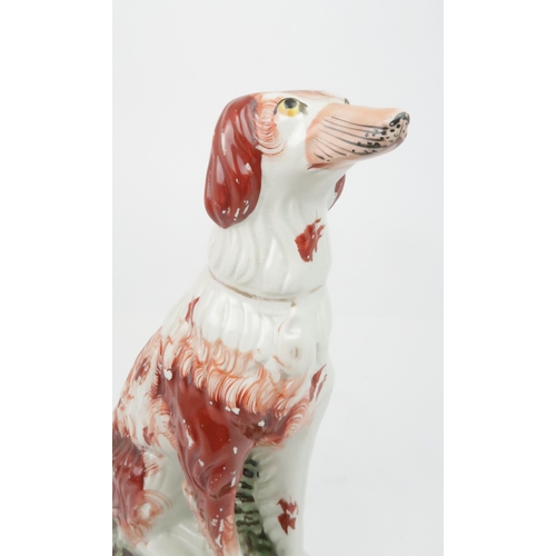 358 - A 19TH CENTURY STAFFORDSHIRE POTTERY DOG possibly an Irish Setter, modelled seated with red decorati... 