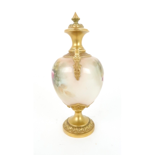 364 - A ROYAL WORCESTER URN AND COVER decorated with roses and foliage, with gilded handles, neck and base... 