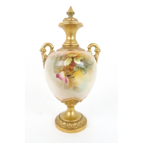 364 - A ROYAL WORCESTER URN AND COVER decorated with roses and foliage, with gilded handles, neck and base... 