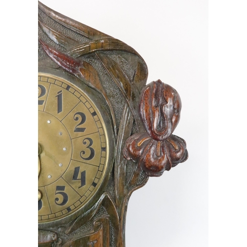 367 - A GERMAN/ AUSTRIAN WALL CLOCK the brass dial with stylised Arabic numerals, the wooden case carved w... 