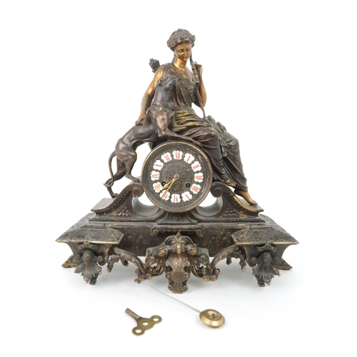 385 - A FRENCH PATINATED SPELTER MANTLE CLOCKmodelled as Diana holding a bow with a dog at her side, the d... 