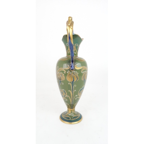 392 - WILLIAM MOORCROFT FOR JAMES MACINTYRE GREEN AND GOLD DECORATED FLORIAN WARE JUGwith stork moulded ha... 