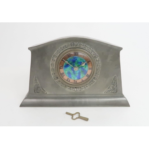 394 - A LIBERTY & CO ENGLISH PEWTER CLOCKthe dial with central mottled blue and green enamel with a co... 