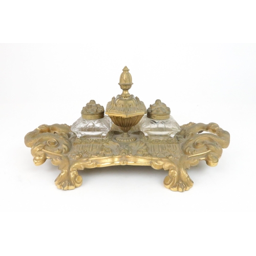 395 - A FRENCH GILT METAL DESK STANDwith two cushion shaped cut glass inkwells and a central lidded pot wi... 