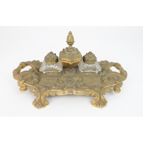 395 - A FRENCH GILT METAL DESK STANDwith two cushion shaped cut glass inkwells and a central lidded pot wi... 